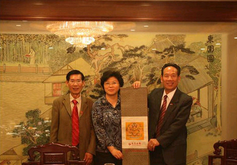 江苏省侨办副主任季俊秋（中）向黄氏宗亲会赠送纪念品.jpg